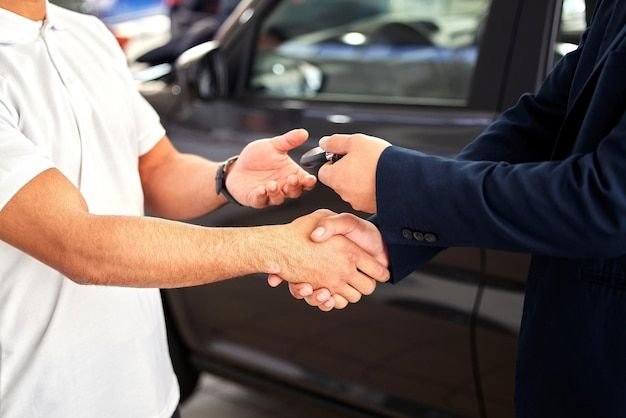 Tim Ronal Automobil menyerahkan kunci mobil bekas kepada pelanggan di showroom Pekanbaru